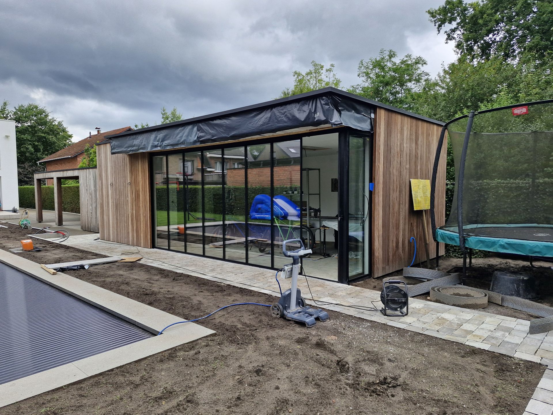 Modern poolhouse met Sliding Glass TWO dubbele glazen schuifwand tijdens afwerking van tuin- en zwembadproject